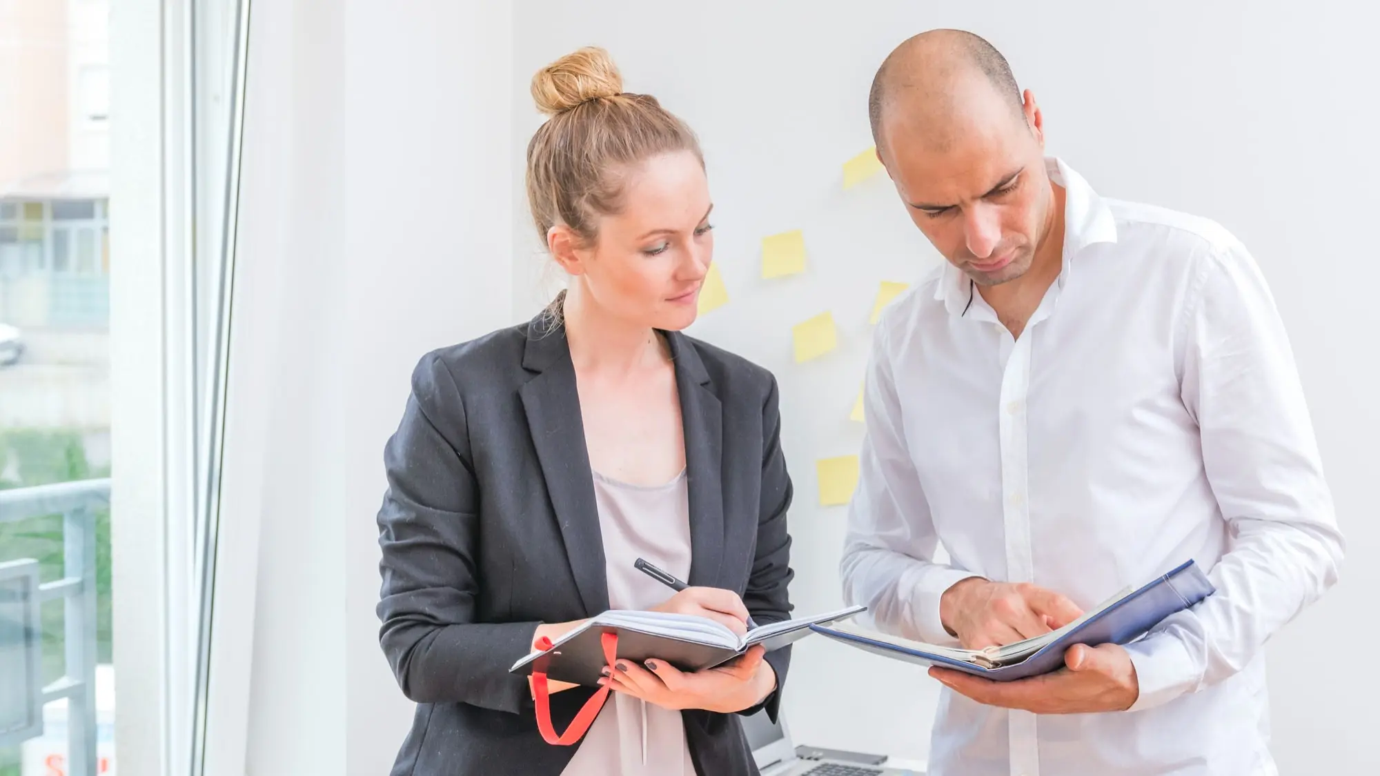 empresarios-masculinos-femeninos-que-miran-horario-diario-min